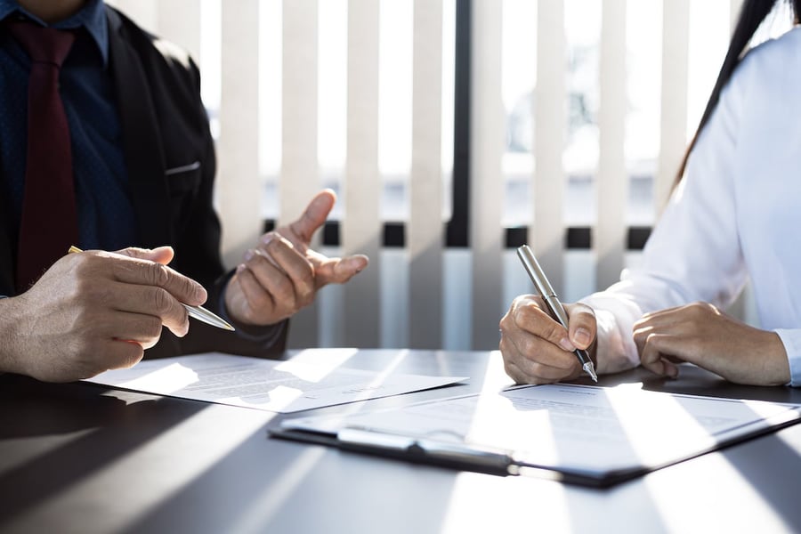 The IT expert and the customer are signing an agreement with their IT company, accepting the terms and benefits.