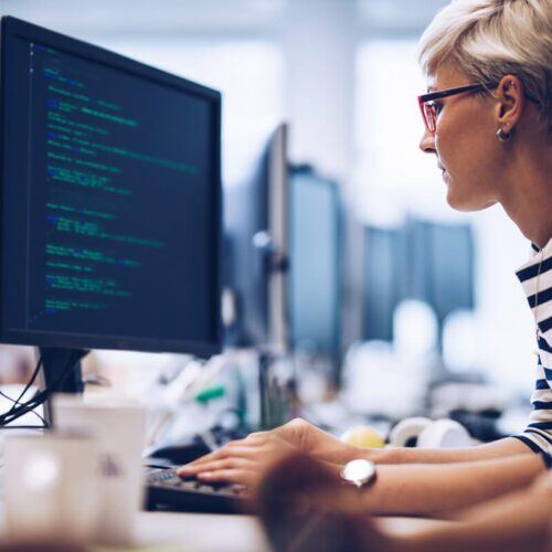 Short haired computer programmer working on a new software in the office.