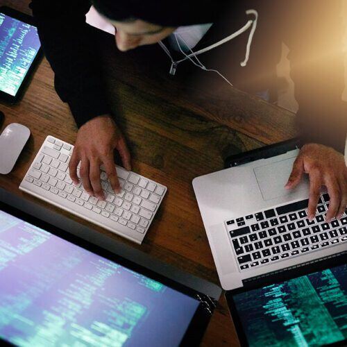 High angle shot of a hacker cracking a computer code in the dark