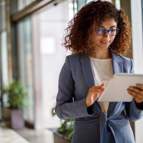 Young businesswoman using digital tablet indoors